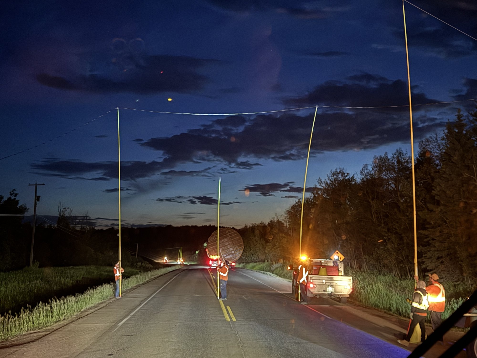 Northland crew guiding an oversize load under power lines at night